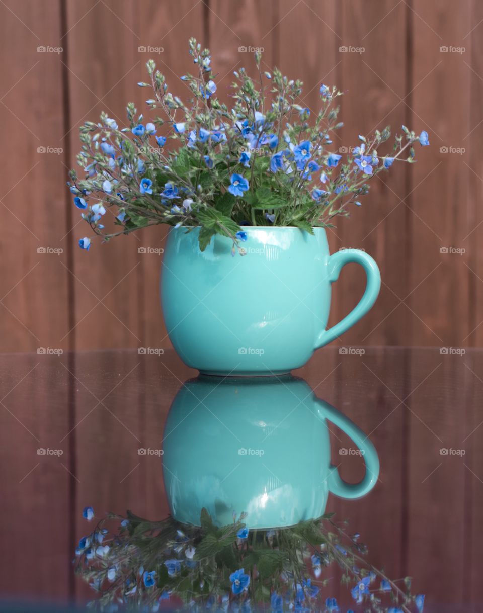 Blue flowers in a turquoise cup