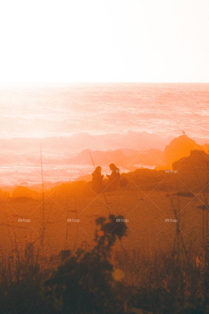 Nice couple in love at the beach at sunset 