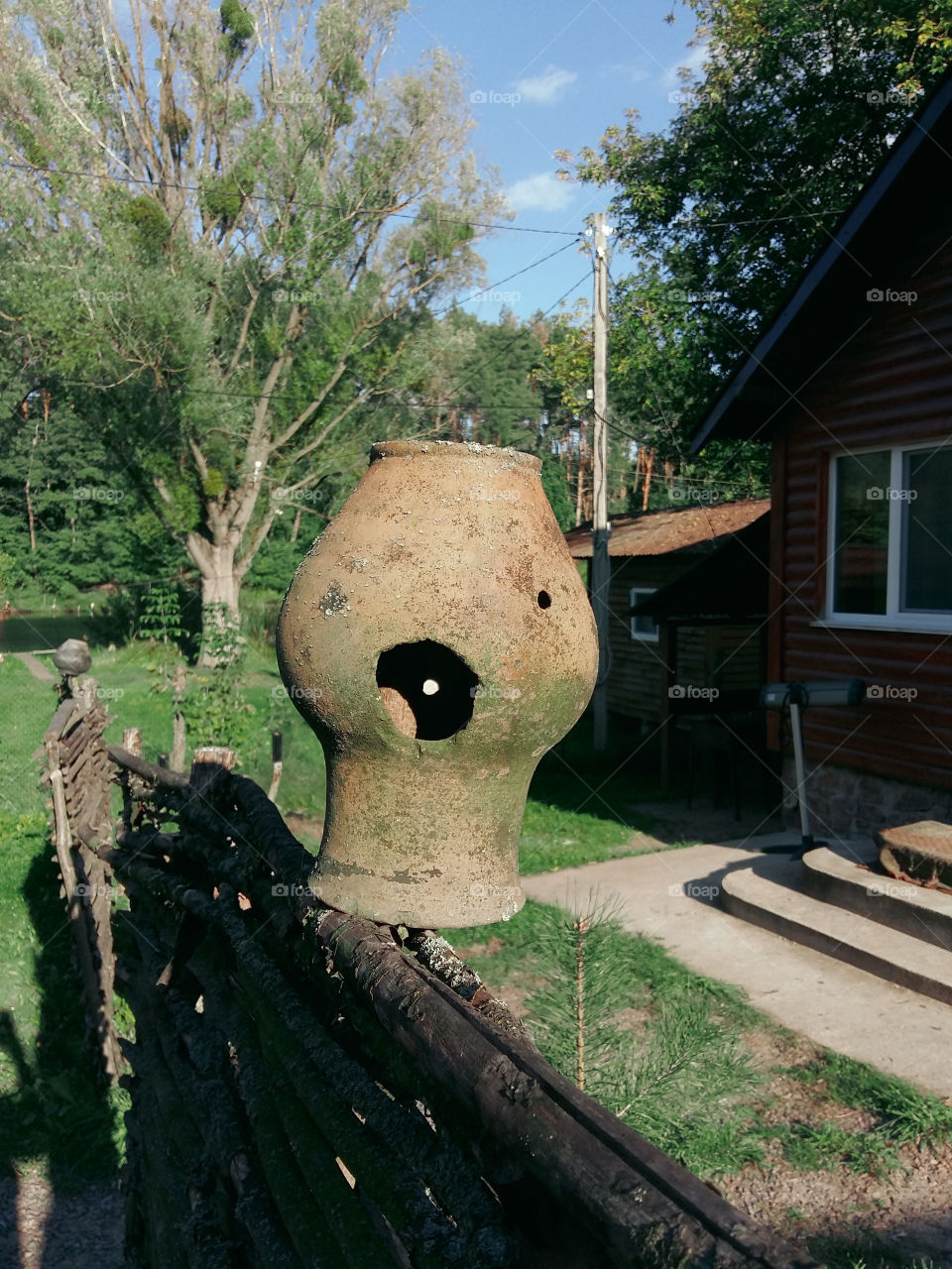a broken clay pot on the fence in the form of a smile