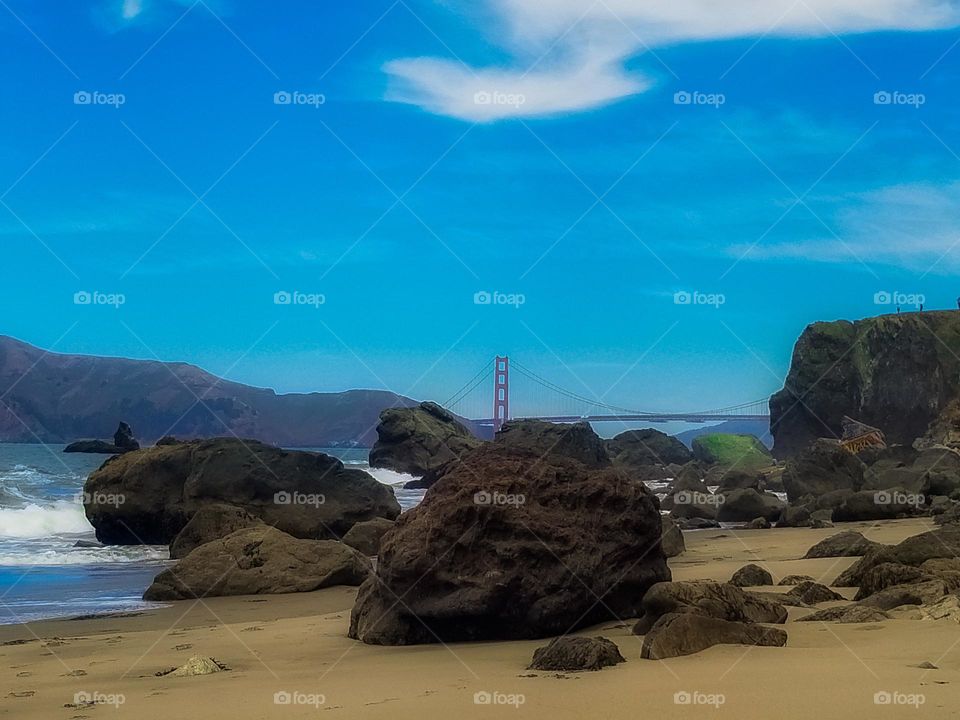 Lands End Beach San Francisco with a view of the Golden Gate Bridge in the background, rocks, ocean , blue sky 