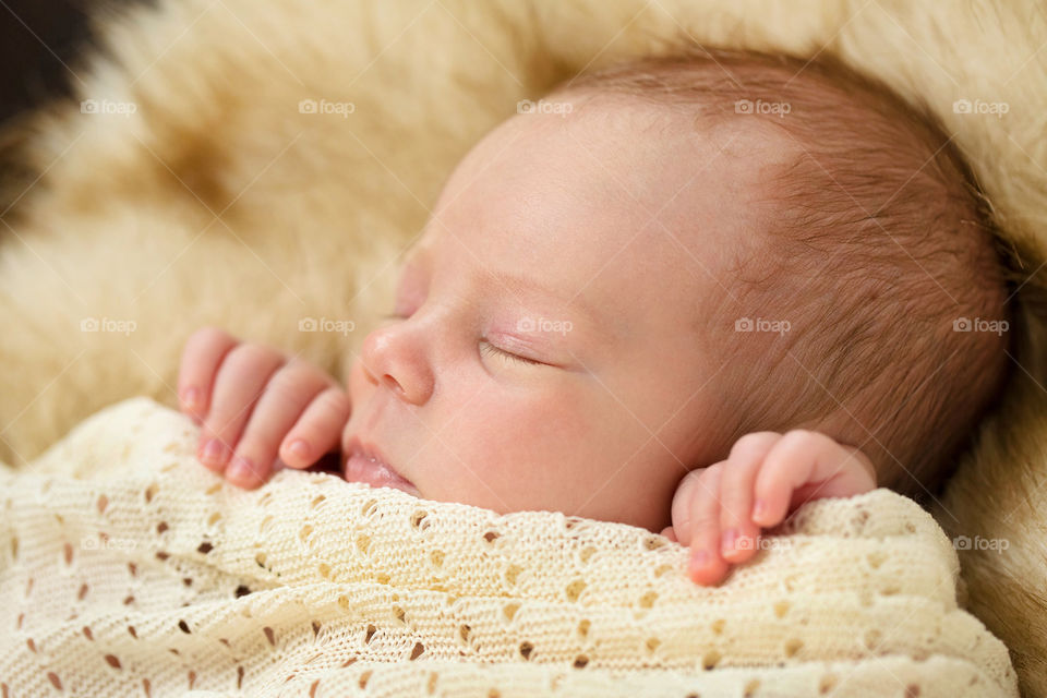 Close-up of a cute baby sleeping on bed