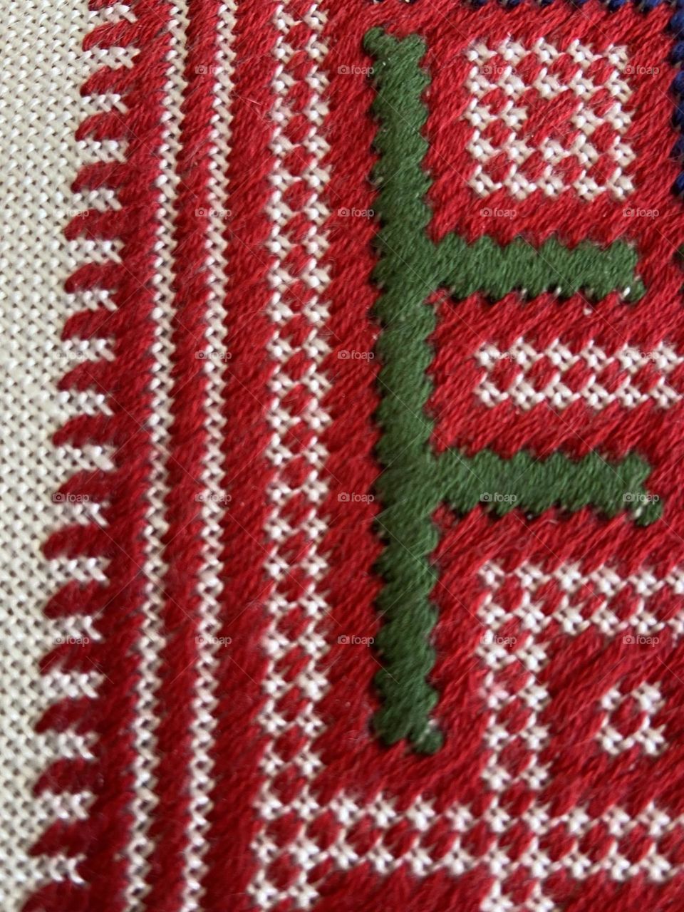 A delicate and artistic display of needlework in a red and green pattern.