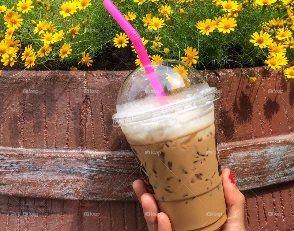 Hand holding ice coffee