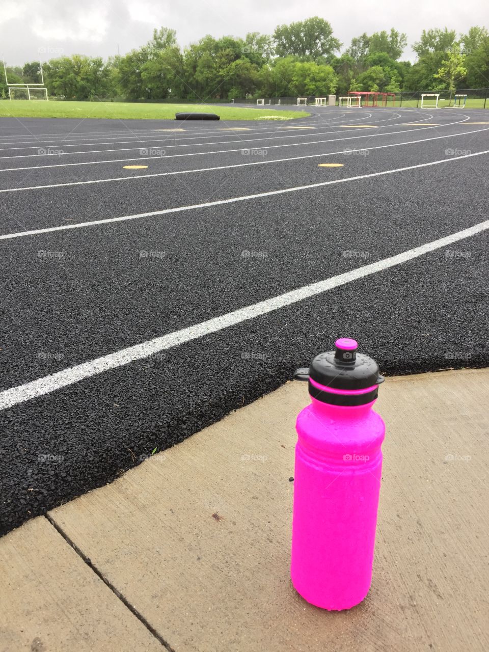 Ready to run. Water bottle next to running track. 