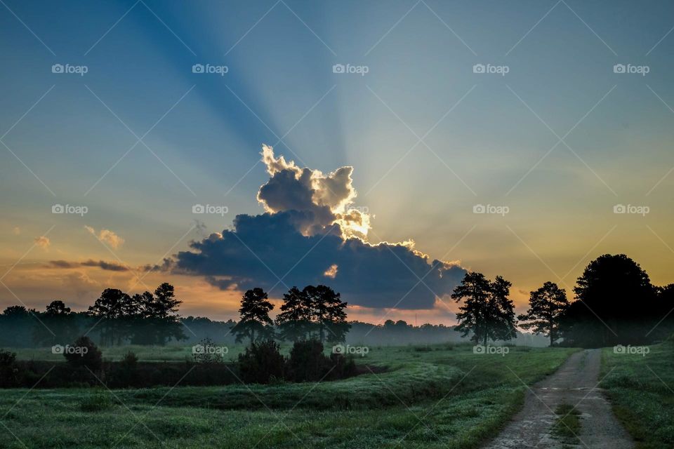 Light from the rising sun blasts around a heavy cloud. Raleigh, North Carolina. 