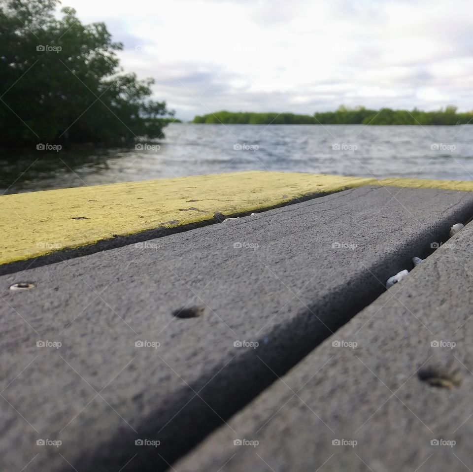 Grey and yellow dock overlooking the cold bay water