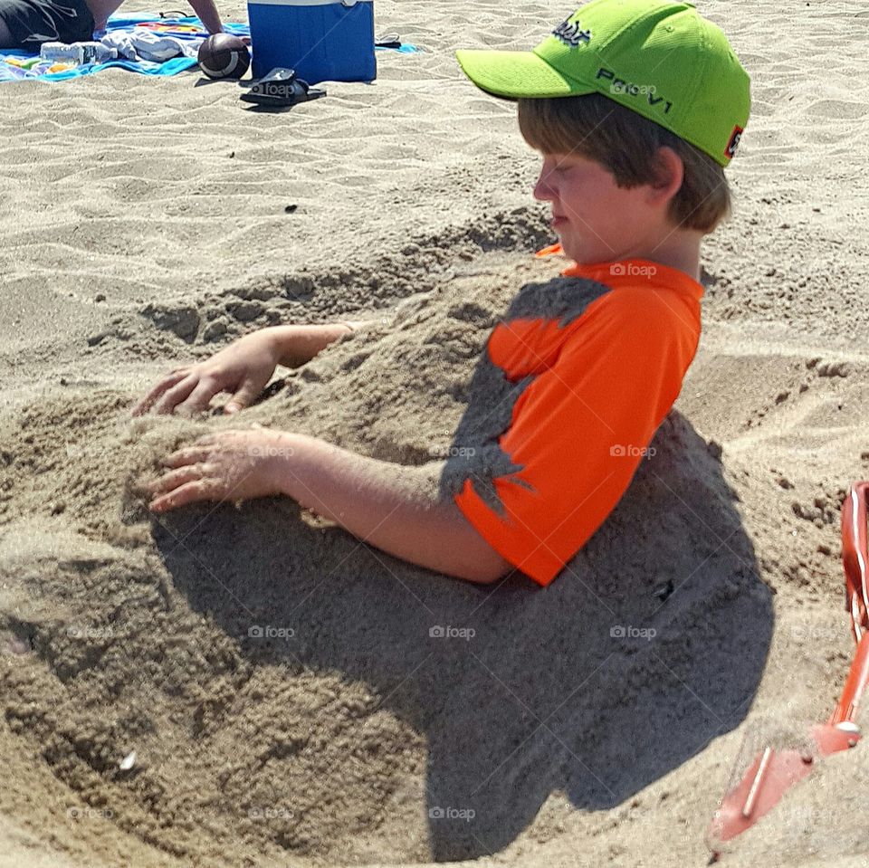 boy buried in sand