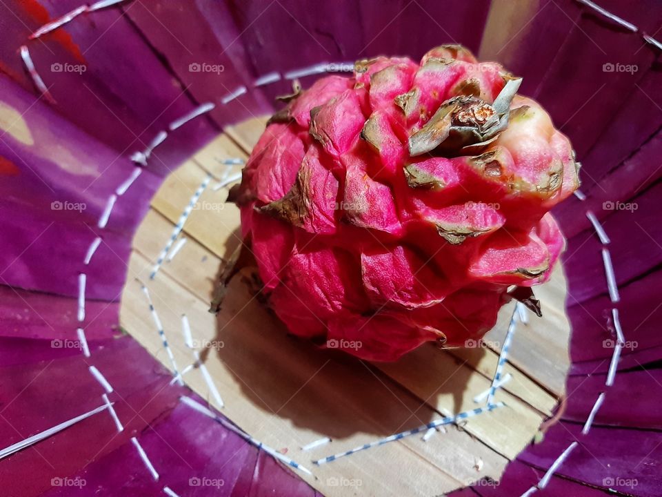 A fresh and healthy red dragon fruit in the basket.