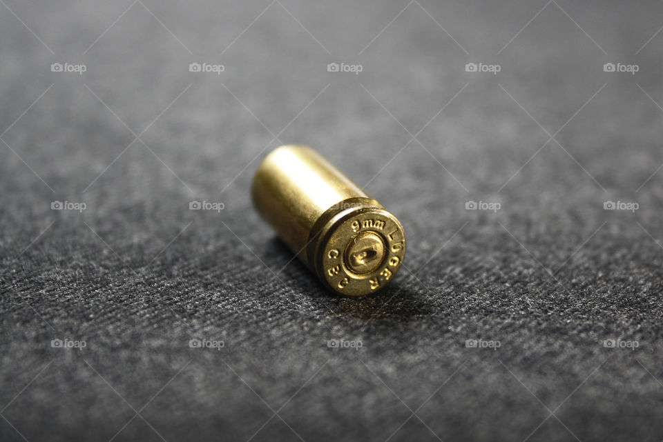 Golden metal bullet shell on grey background
