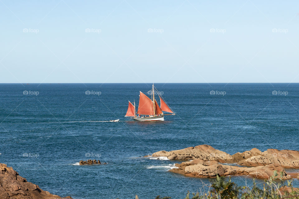 red sailing ship on the ocean