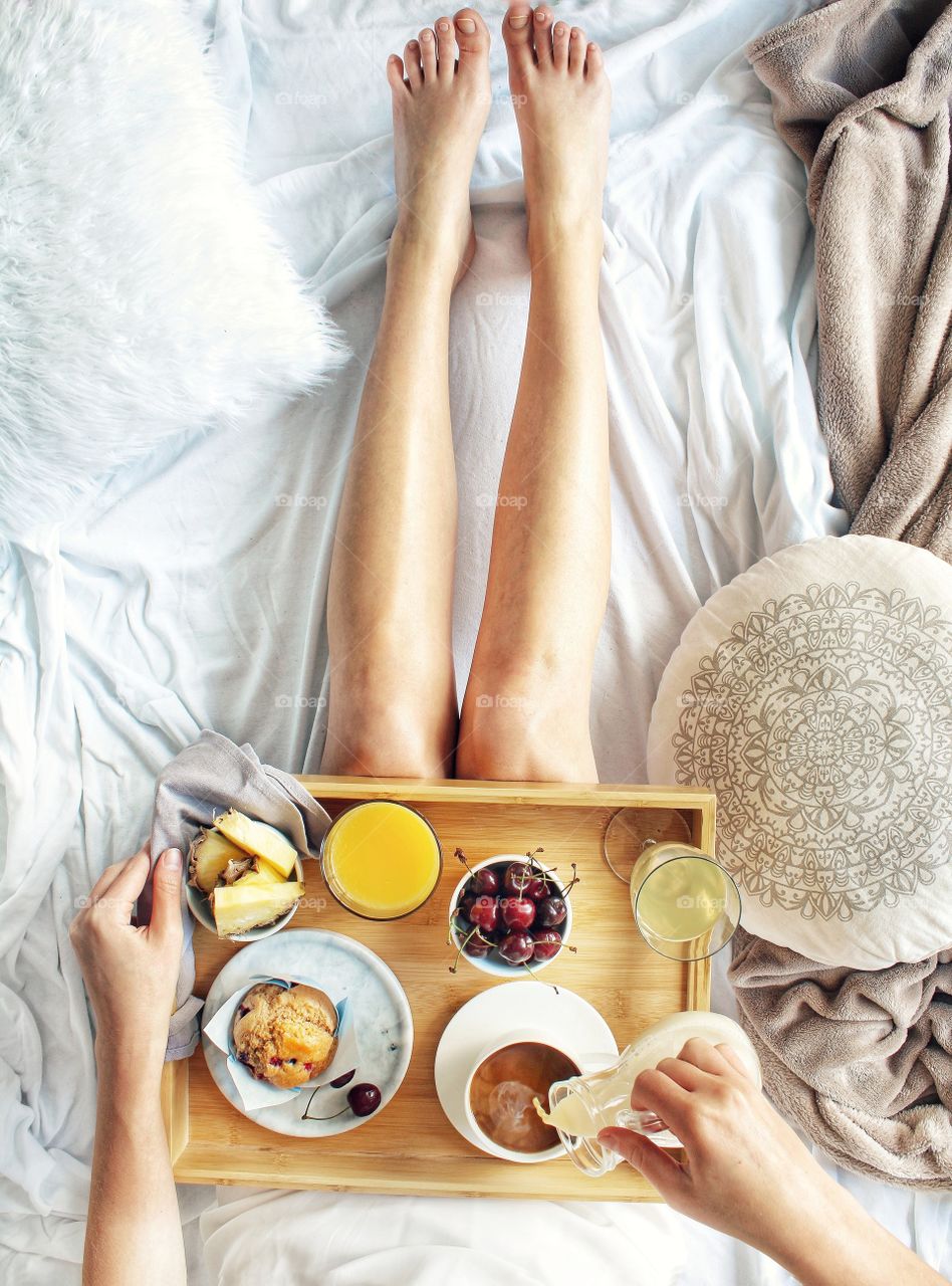 Breakfast in bed with coffe, fruits and muffin