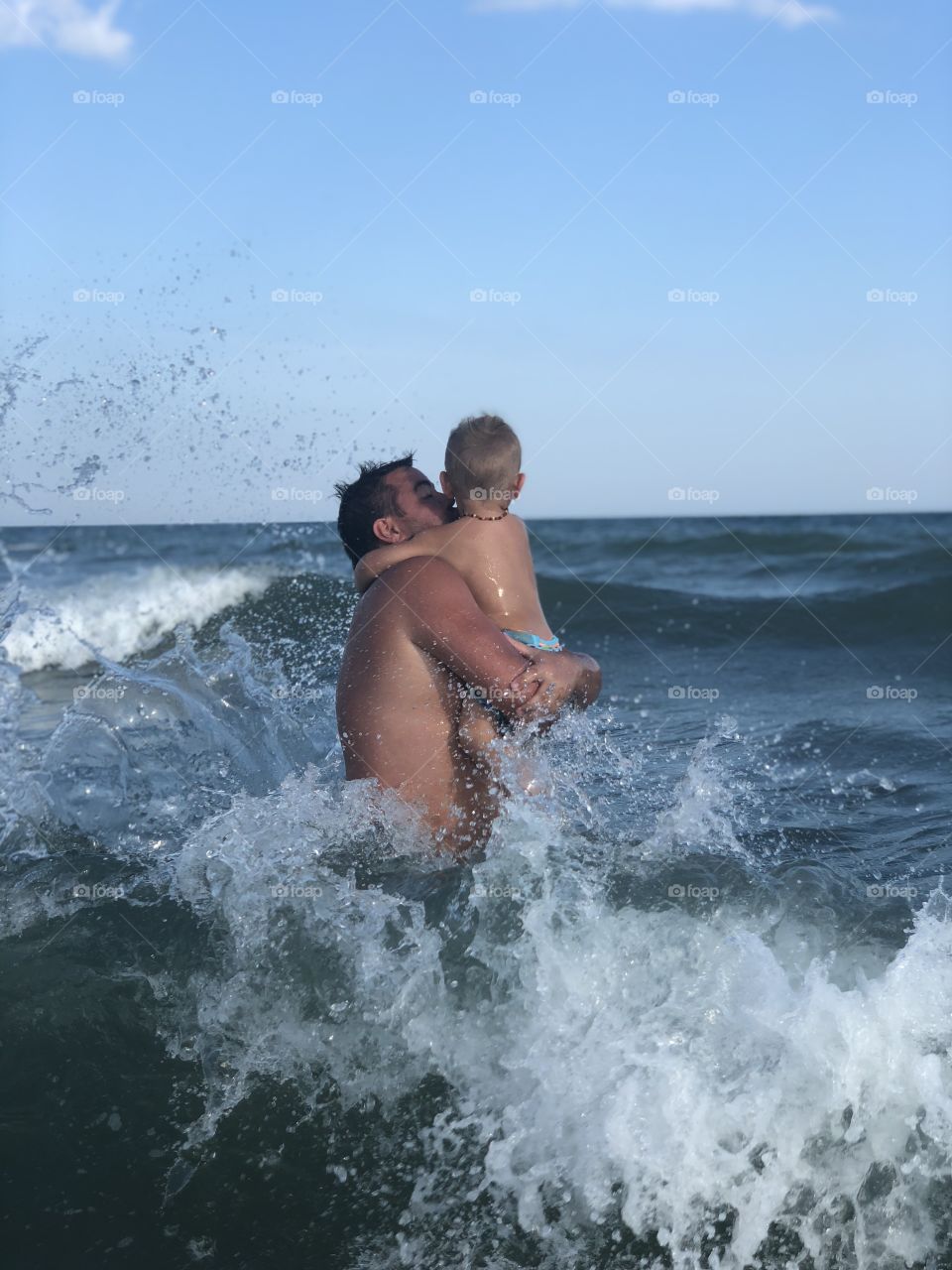 Father-son splashing in the waves on the SC shores. (Isle of Palms). 