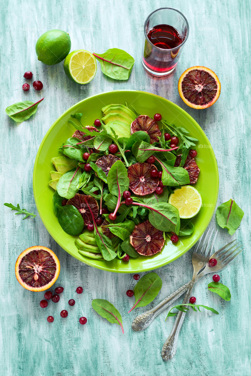 Salad with red orange fruit, lime, avocado and spinach leaves