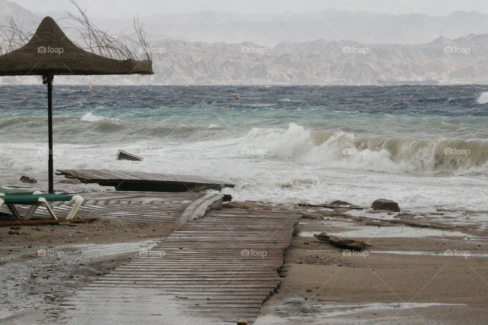 Big storm over the Red Sea. Usually very calm sea without waves. At this storm big waves crash over the beach and cause huge destruction 