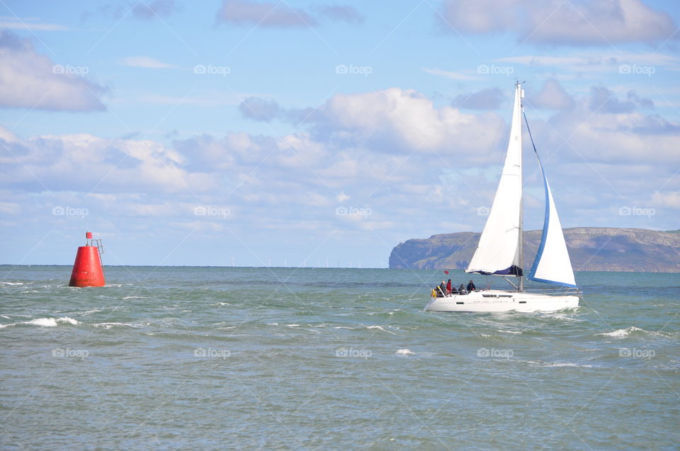 A small Yacht sailing off Penmon Point, Anglesey, Wales UK