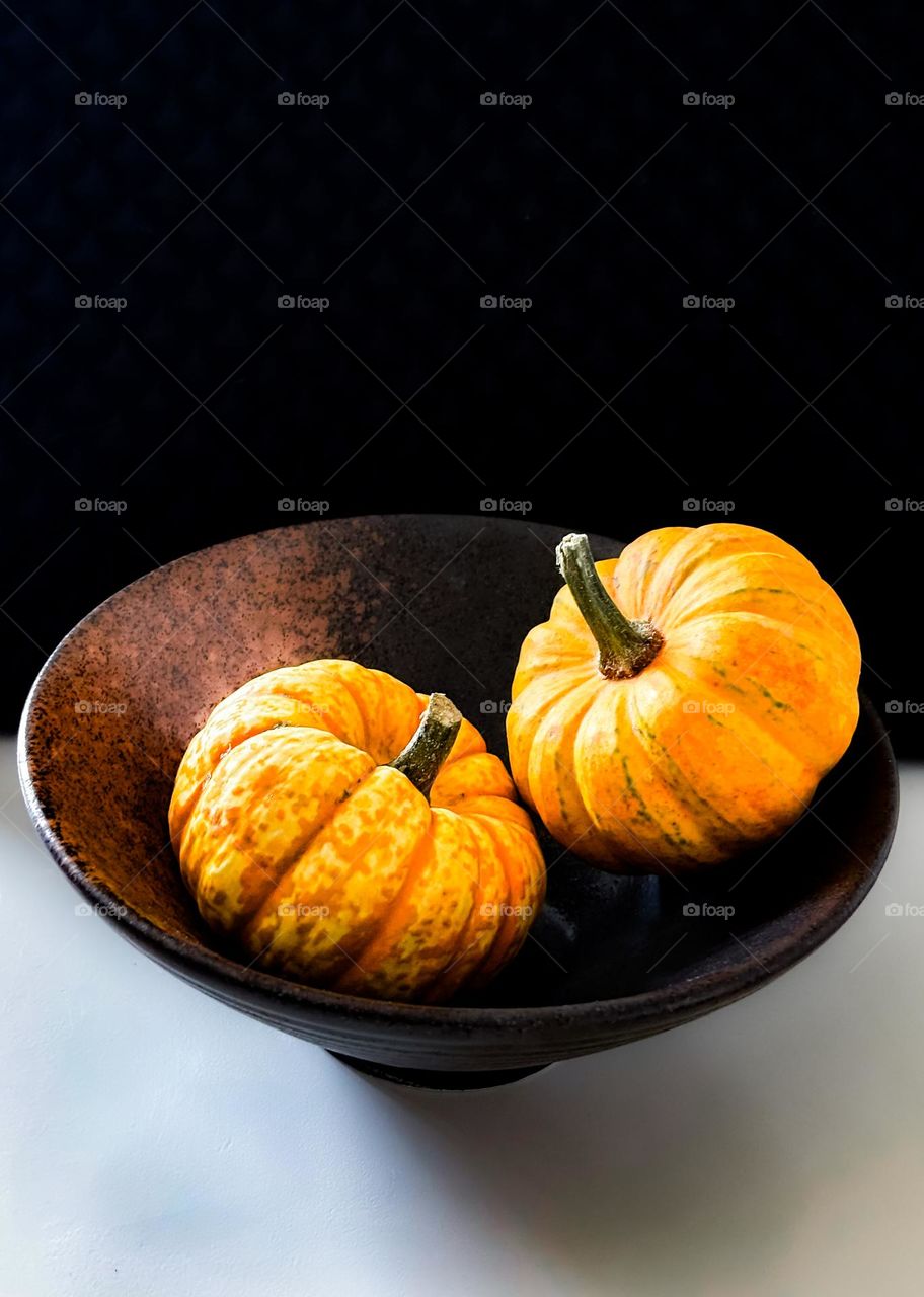 Two pumpkins in a bowl