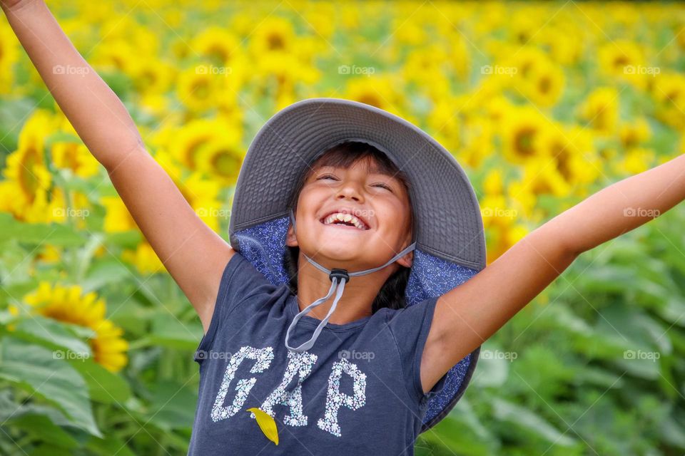 Happy cute girl in a sunflower field