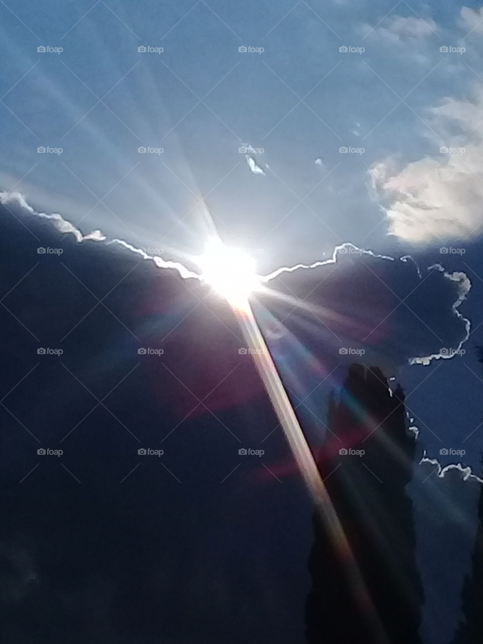 imagen del sol marcando el límite entre los espesos nubarrones de tormenta y el azul del cielo de verano despejado.
