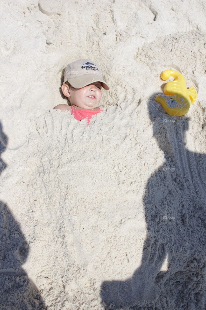 Child covered in sand