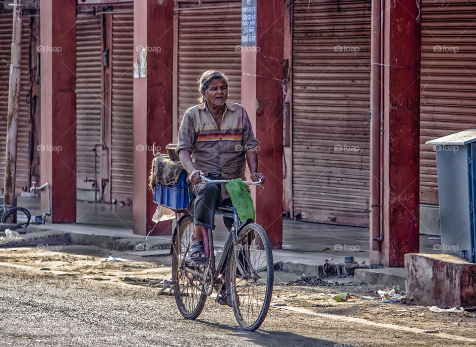 october 2018, babu bazaar, jaipur rajasthan india.when rich people do bicycling to shed weight there a poor man is bicycling to survive his life with keeping weight on bicycle