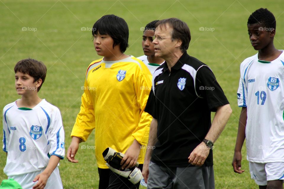 Coach and players on soccer field