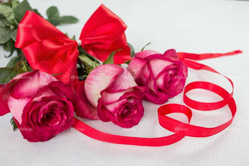 a bouquet of red roses and red bow