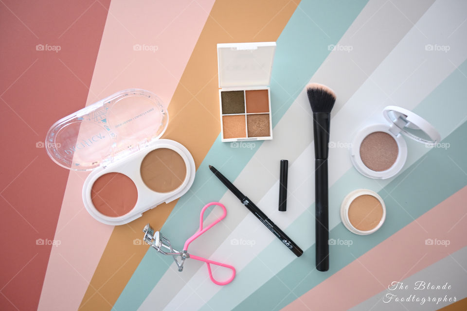 Flat lay, soft pastel arrangement make up cosmetics top down view