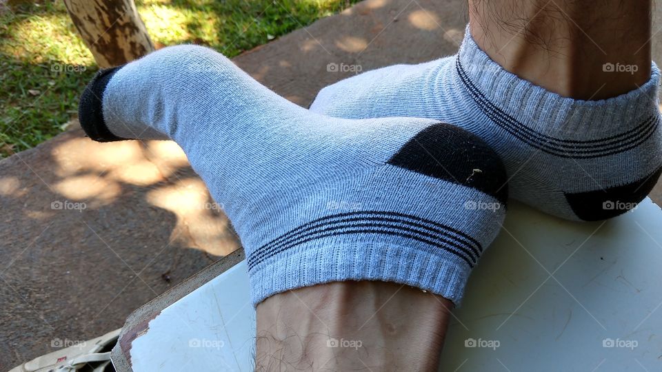Pés masculinos calçados com meias.