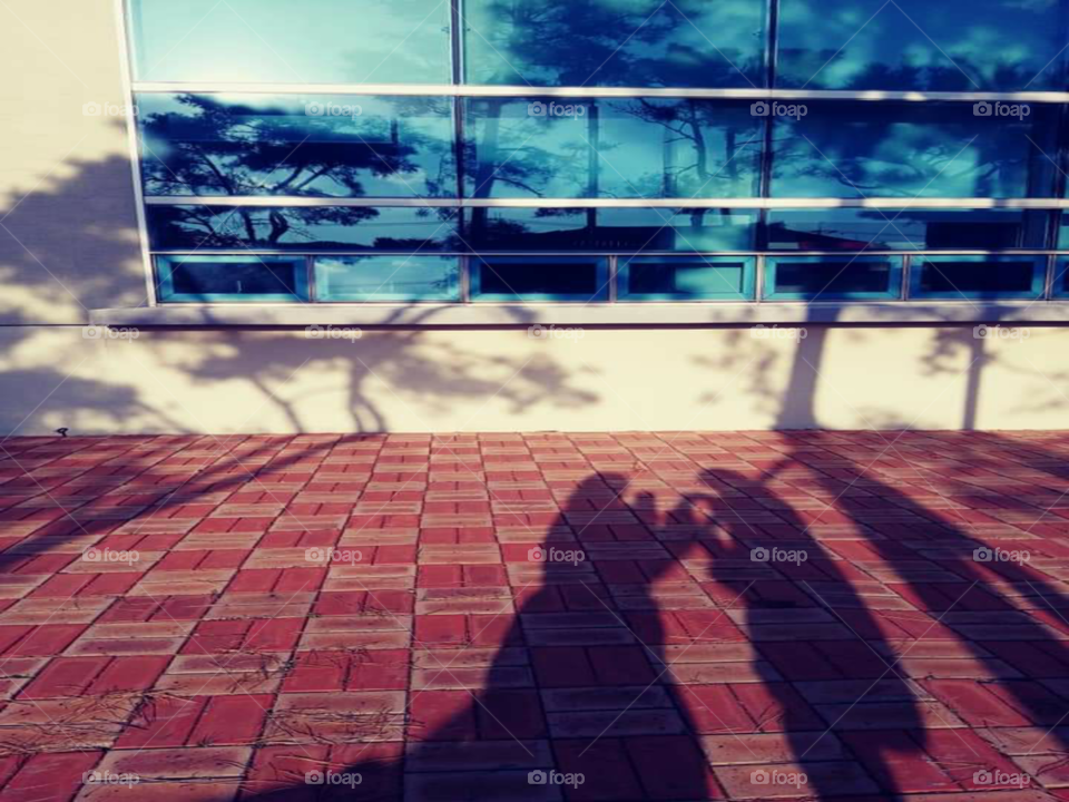 an shadow of a mother and a child. the mother is giving some snacks to her hungry child.