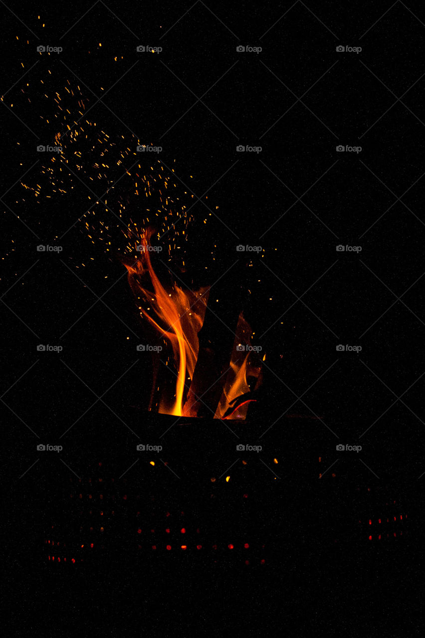 Shape ellipse and circles using fire and sparks on a dark night.