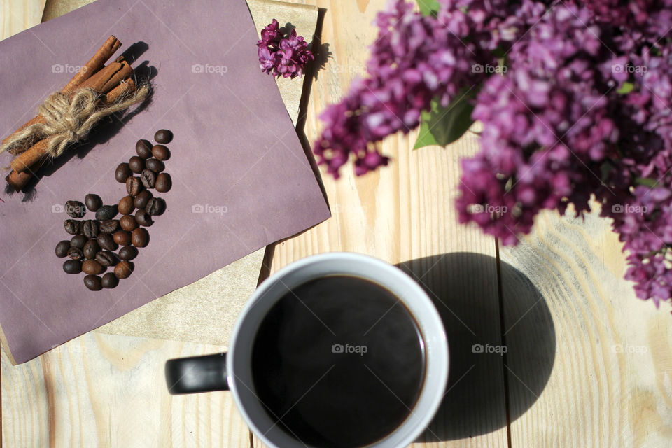 Coffee, hot drink, drink, grains, coffee beans, cinnamon, sticks cinnamon, lilac, flowers, purple flowers, bouquet, flowers in a vase, vase, rest, morning, work, cafe, restaurant, Gingerbread, cookies, dessert. bakery products. Heart, sweetness, dessert in the form of heart, chocolate dessert