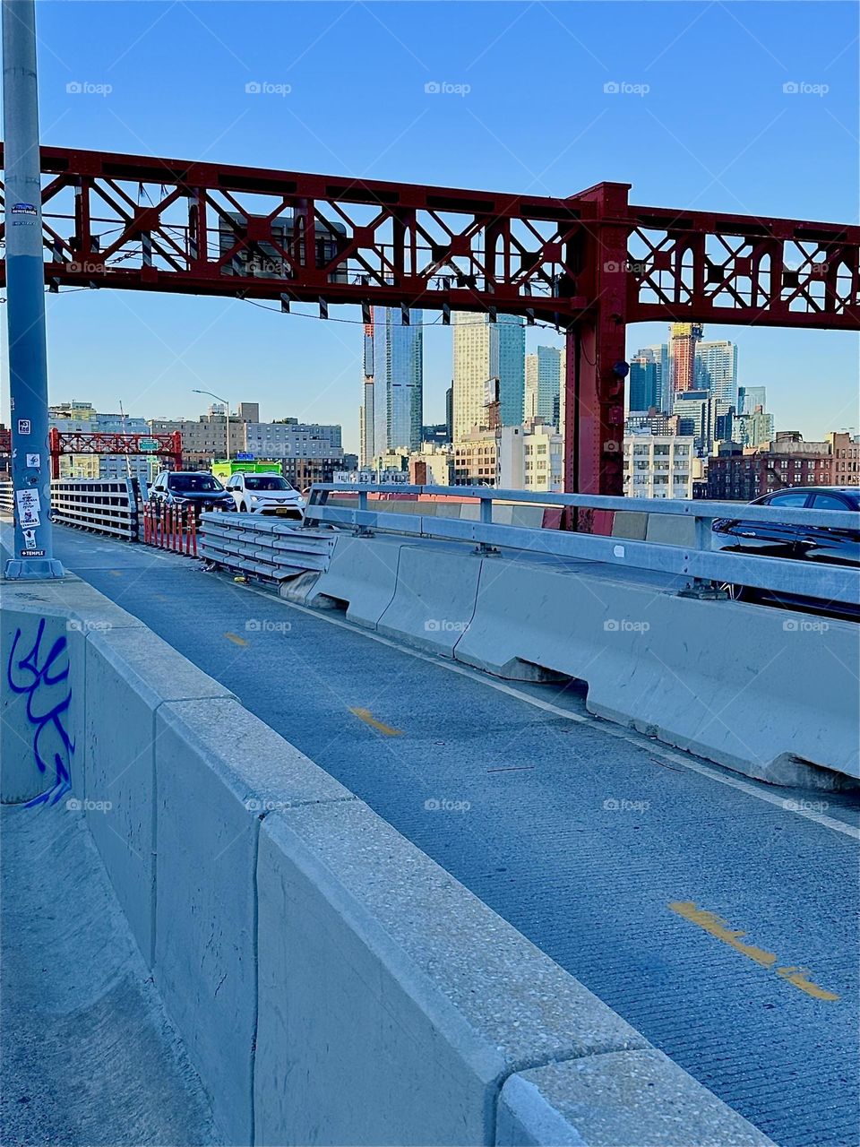This is the pedestrian and the bicycle lane of the “Pulaski Bridge” at “Newtown Creek” that connects “Greenpoint”, Brooklyn to LIC, Queens in the direction we are facing. The red metal gate keeps the style of the bridge. 2024. Hypnotic Productions