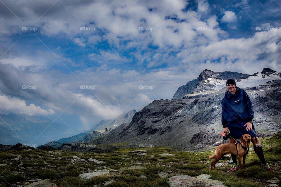 hiker with dog in the alps.