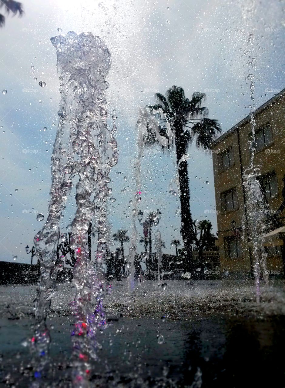 water in motion: Close up of water splash from a fountain with colored light