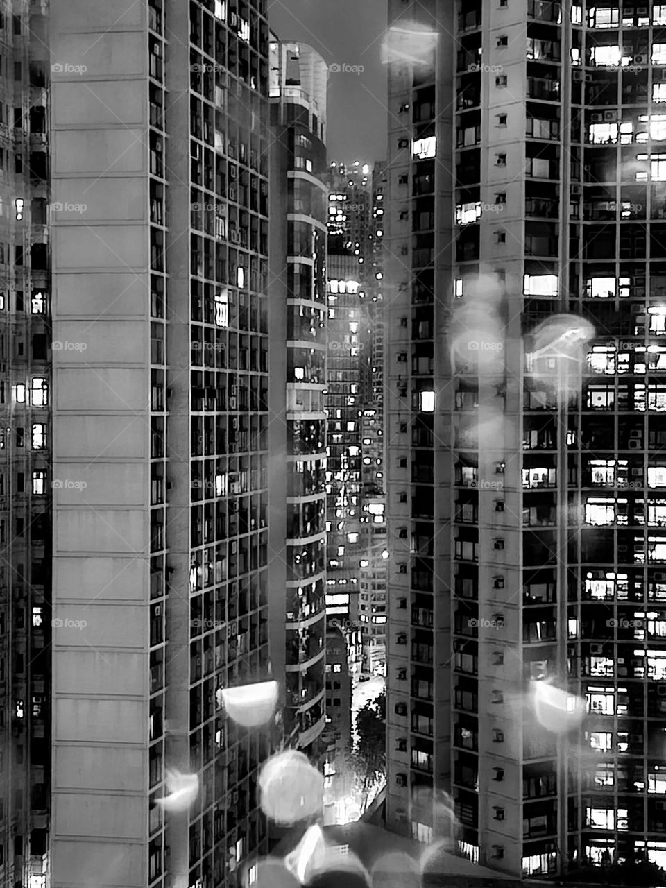 Looking out a window at the neighboring buildings on a rainy night in Hong Kong