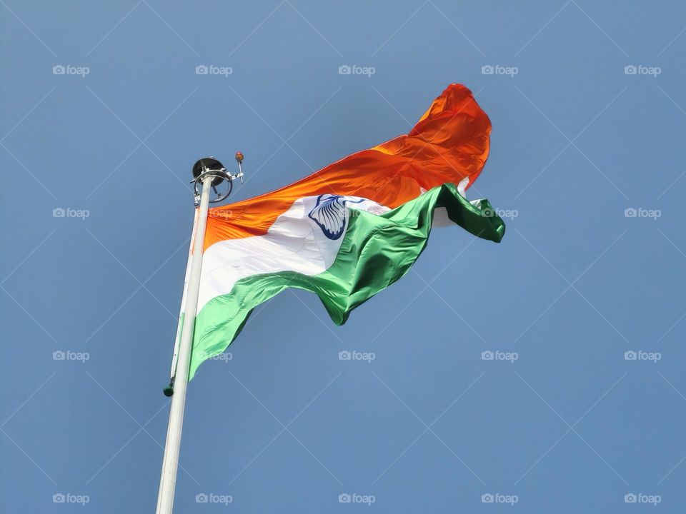 Indian flag high and brightly lit with sunlight