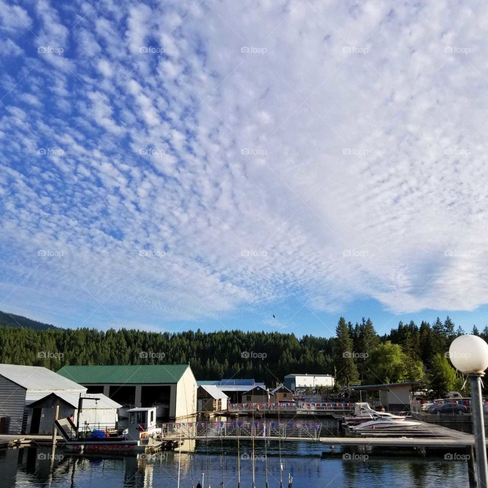 clouds over a lake marina with a hint of blue sky