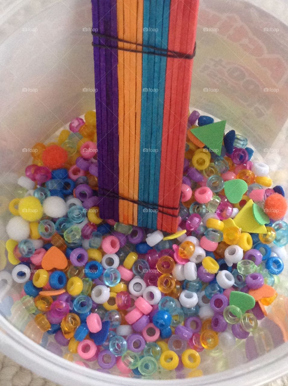 Different colors of popcicle sticks and colorful beads for arts and crafts supplies. 