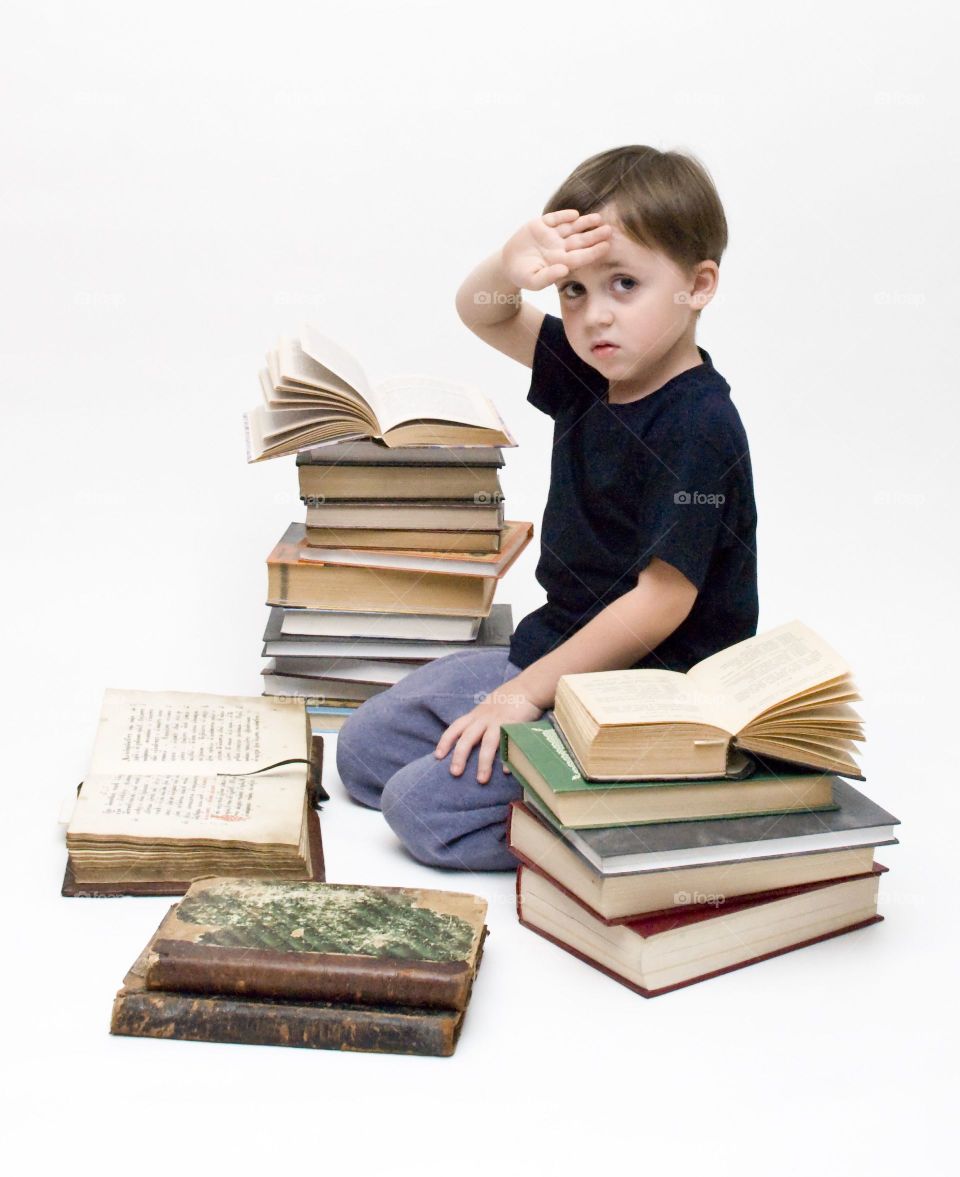 Boy sitting in middle of books