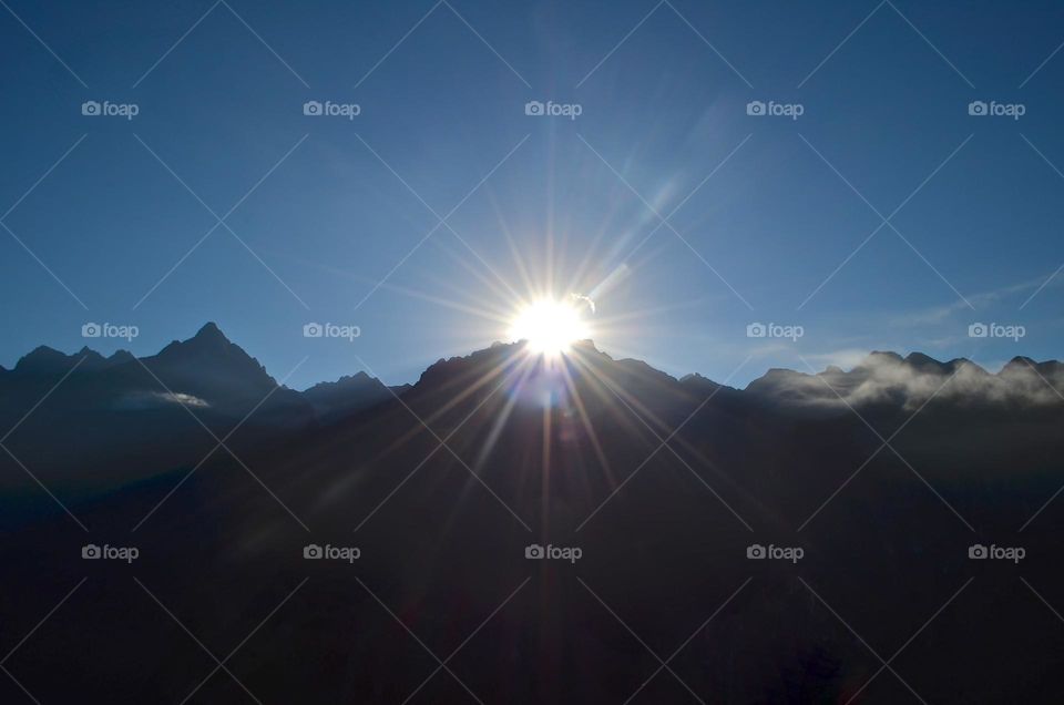 Sunrise over the mountains at Machu Picchu archaeological site in Peru. Many travelers wake up very early just to experience this magical "nature and travel" wonder. 