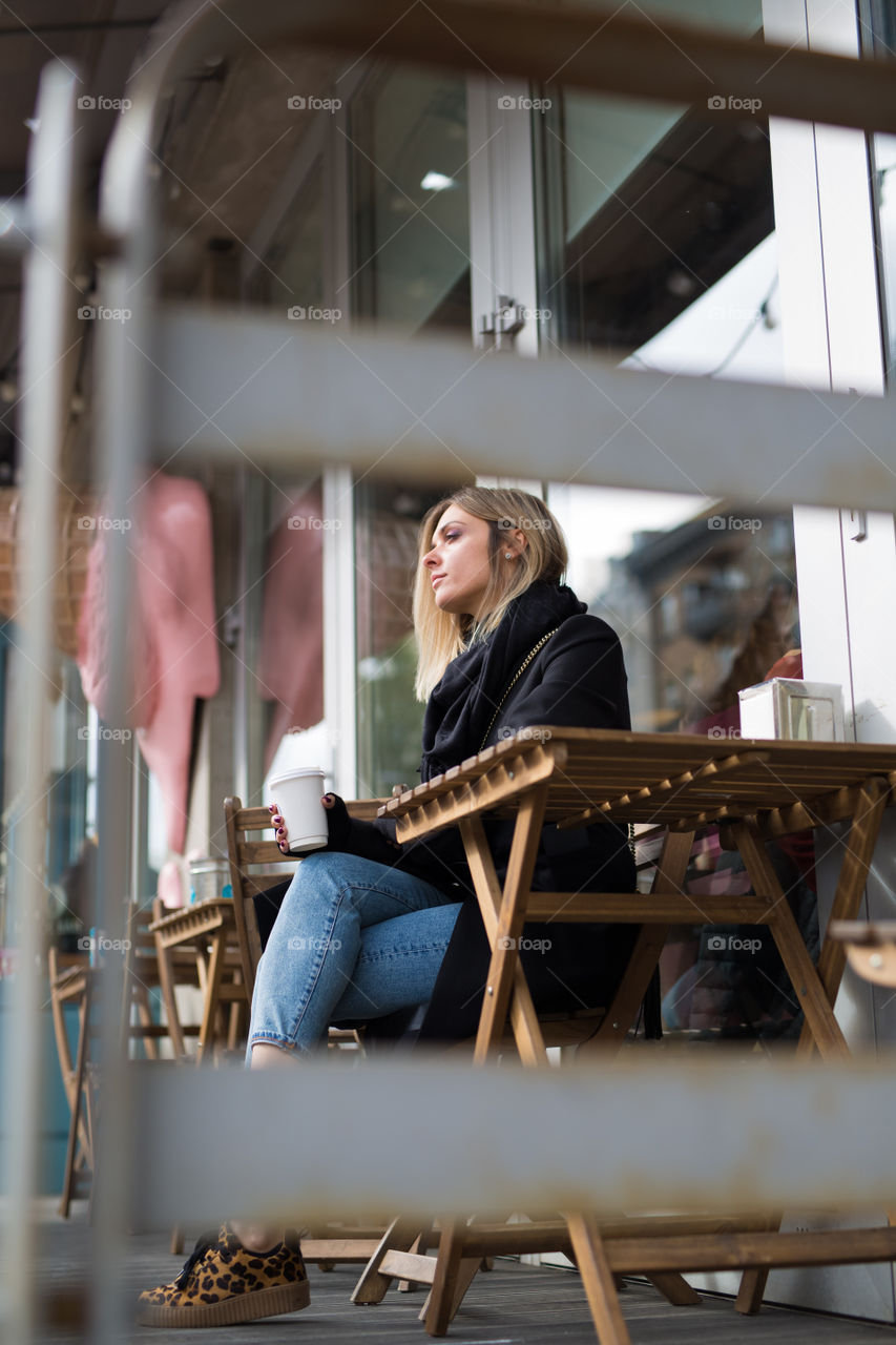 social distancing, the girl drinks coffee alone, on the terrace, takeaway coffee. Beautiful women 