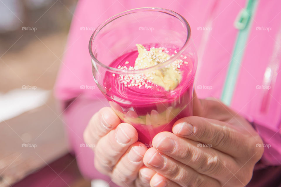 Person holding sweet food in drinking glass