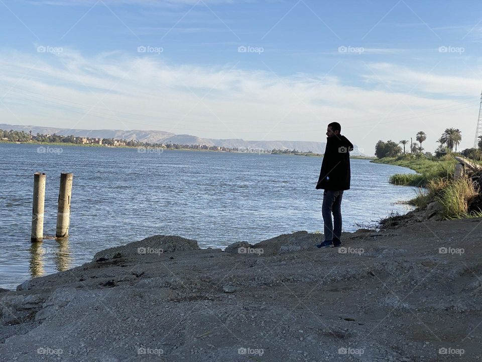 A young man is looking at the sea 