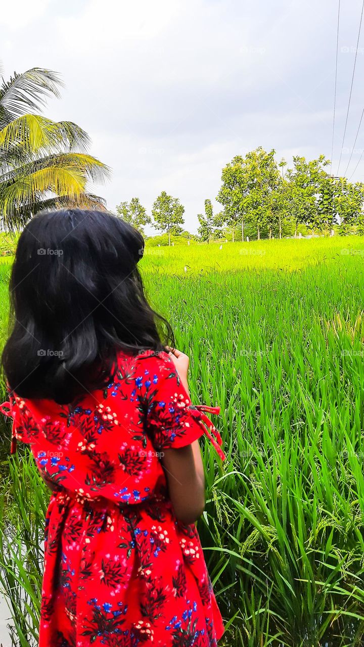 A girl Standing in a village croo field