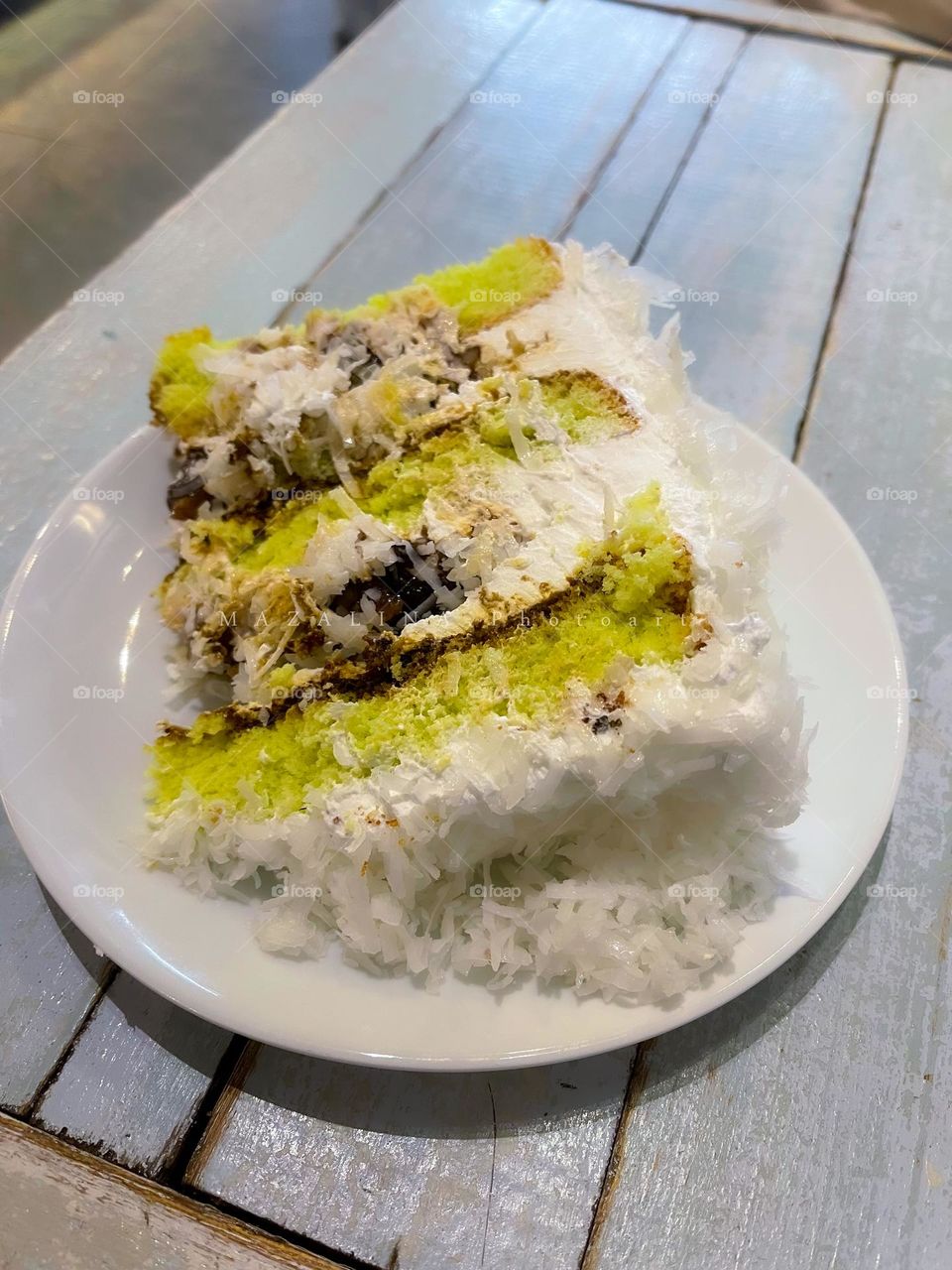 A slice of coconut shredded cake with the aroma of pandan leaf and brown coconut sugar