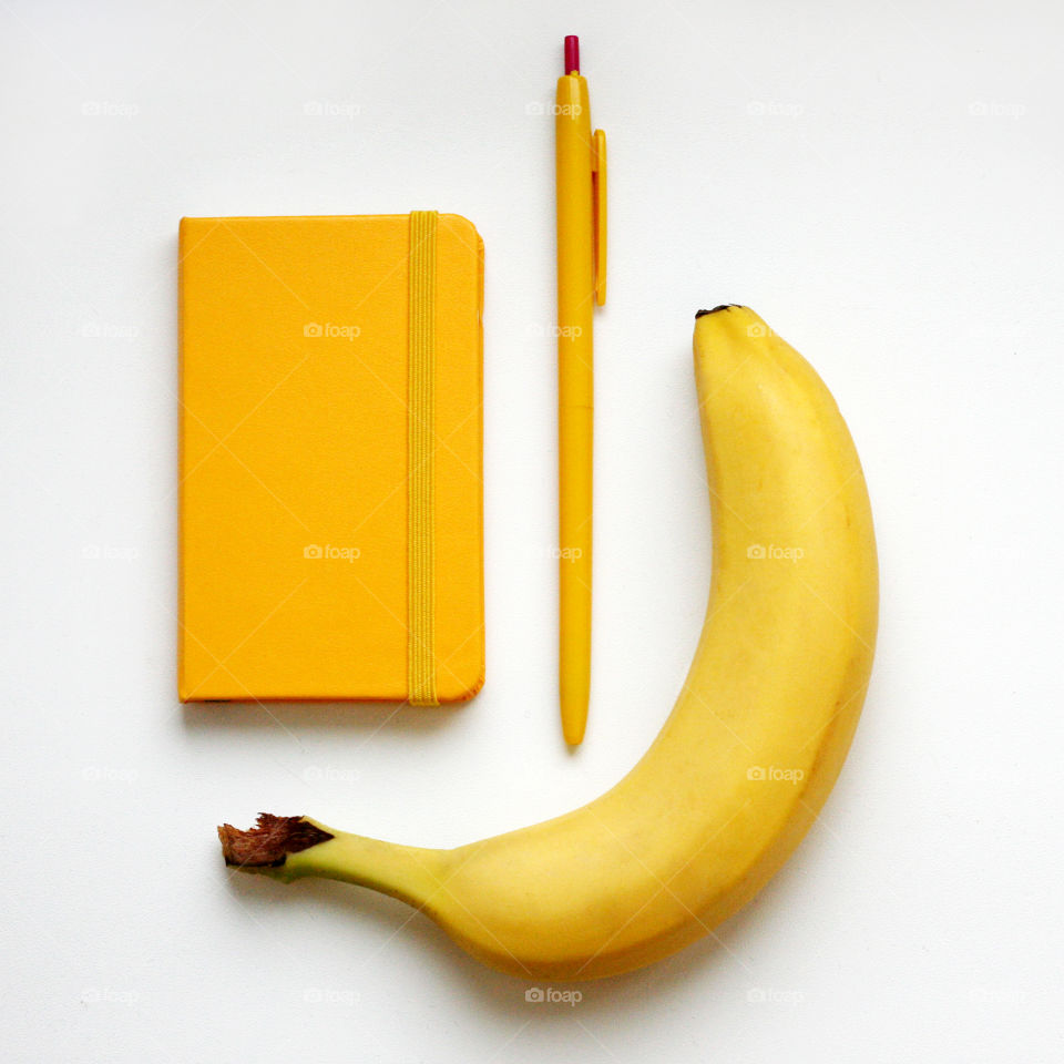 yellow notebook, pen and banana