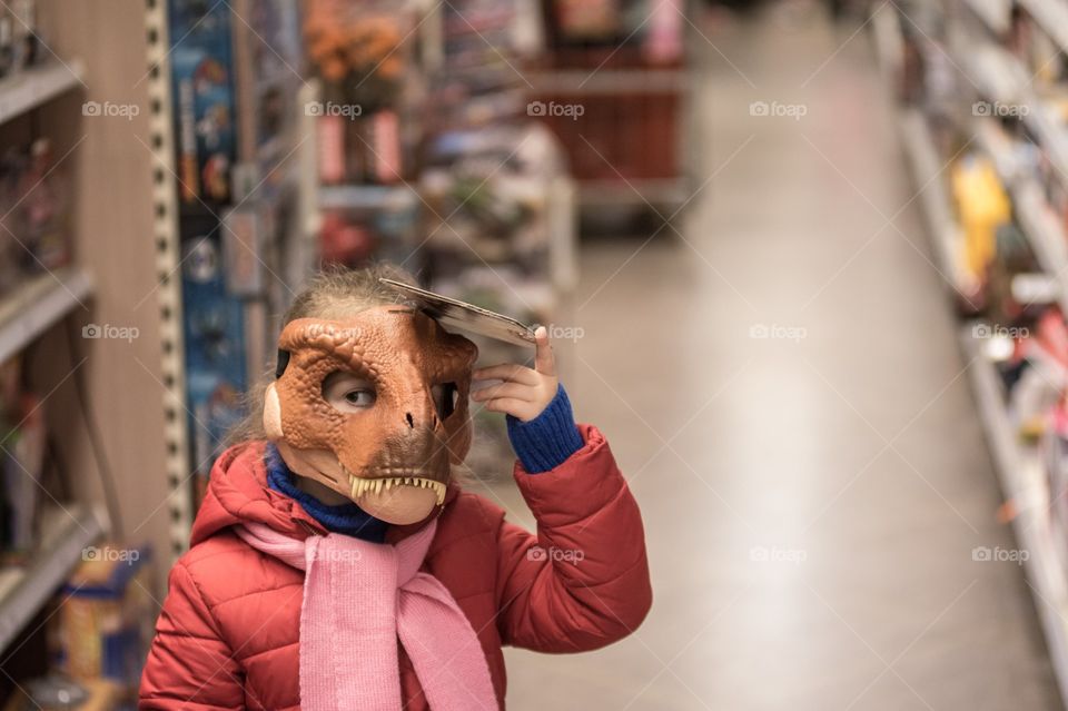 A kid at a toy store trying on a mask