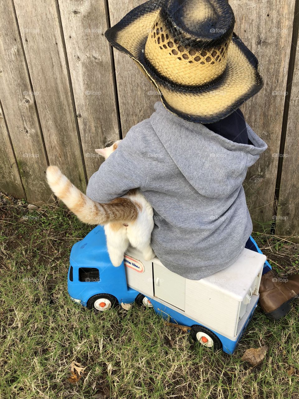 Boy in Cowboy duds spends time with a cat