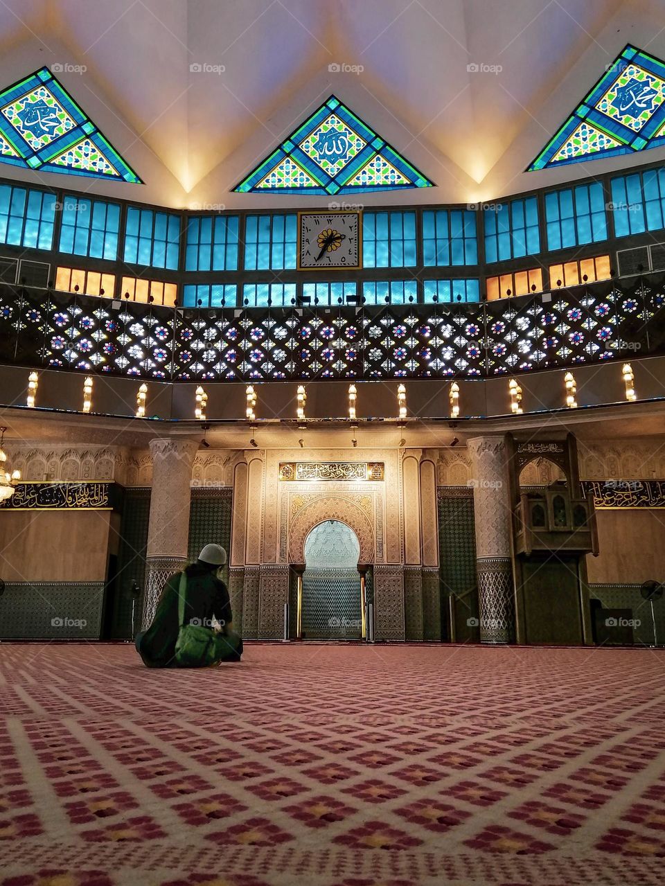 A man is sitting in the mosque after finishing the prayer in the month of Ramadan