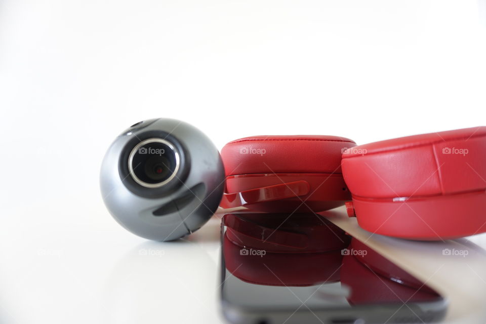 Red headphones, a camera, and a smartphone.